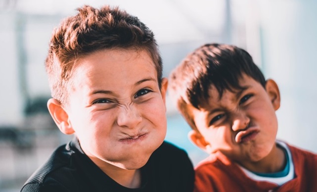 Twee jongens die gekke bekken trekken